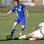 two men going to kick a soccer ball in a game