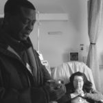 priest administering communion to a women in hospital