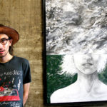 person posing next to artwork