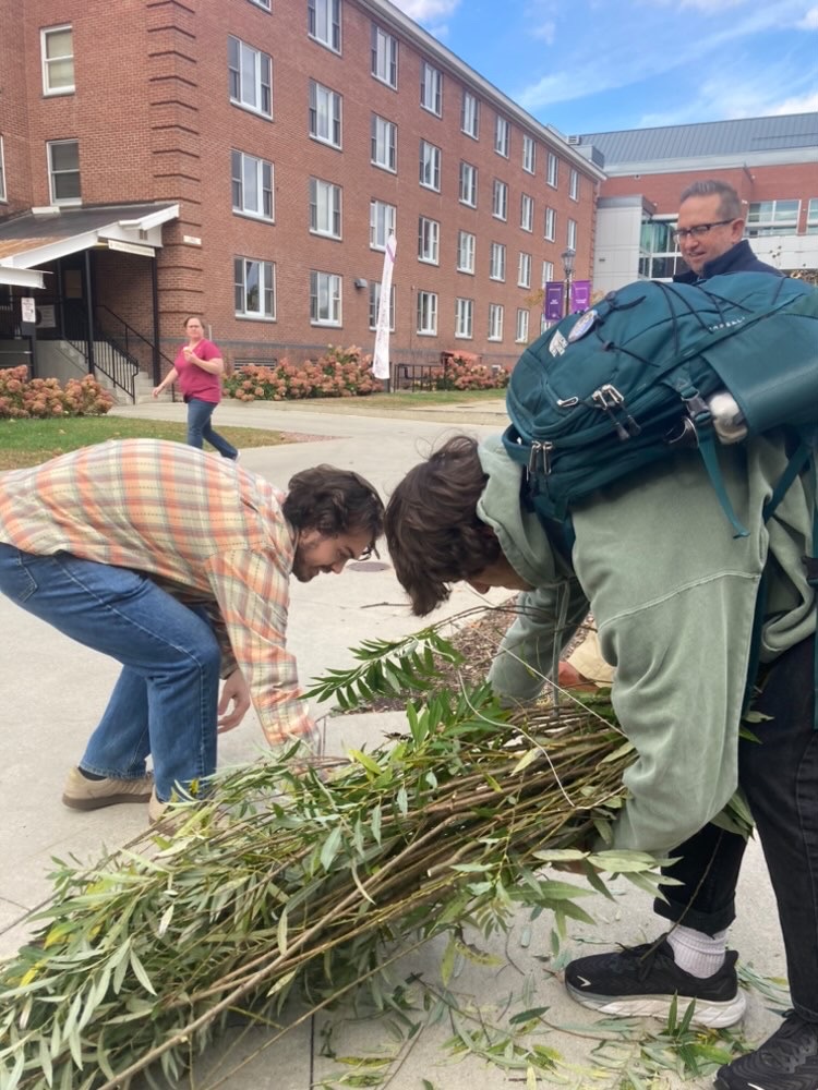 Environmental Restoration students tie together a willow fascine to plant in the Natural Area.