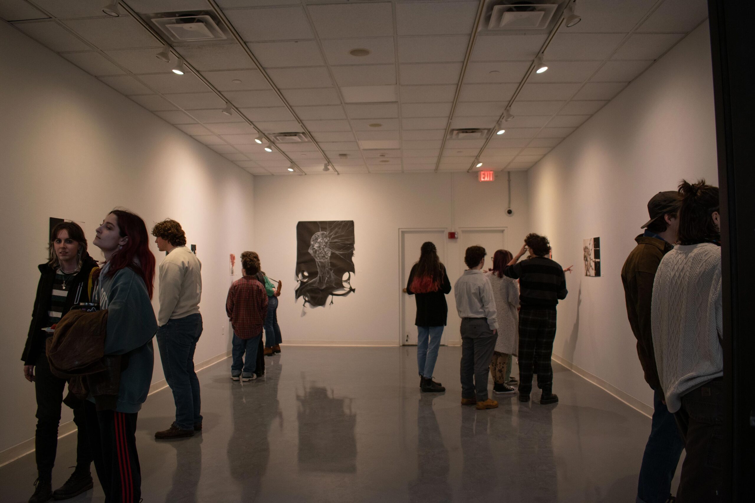 small groups gather around different artwork in the mccarthy art gallery